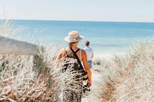Zanzibar dress code – tourists in modest clothing on tropical beach